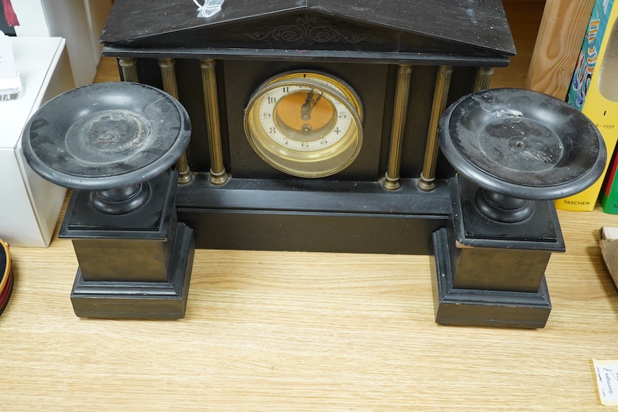 A black slate clock and a pair of garnitures, clock 30cm high. Condition - garnitures worn